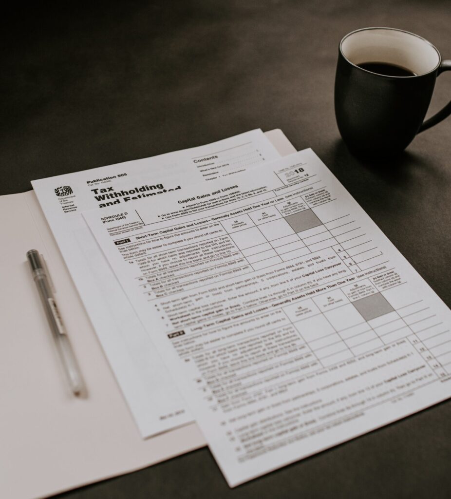 Tax forms on a desk with coffee in the background.